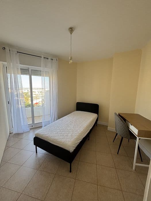 Quarto com cama individual e varanda em Portimão